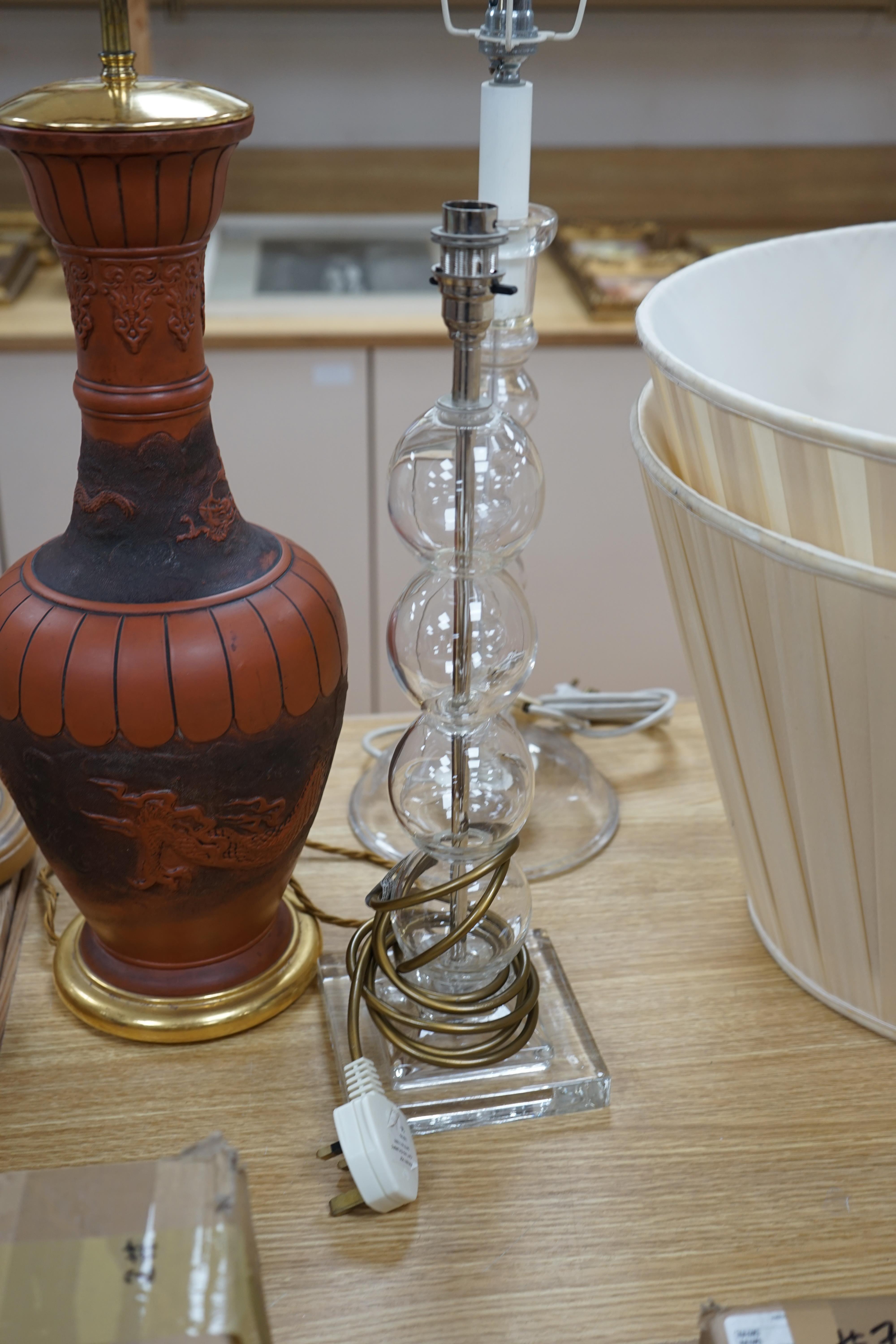 A Japanese terracotta dragon lamp base, two glass and a pair of wooden candlestick lamp bases, tallest 77cm high including light fitting (5). Condition - fair to good